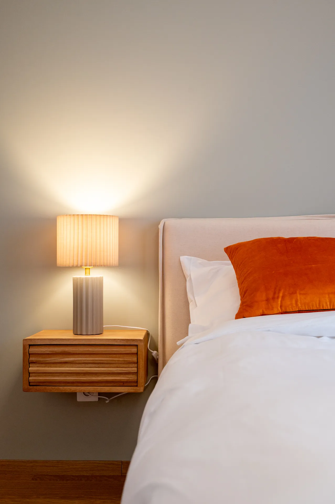 Photo d'une chambre standard — tête de lit, coussins et lampe de chevet